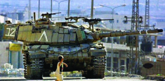 “ISRAEL TEM OS JORNALISTAS PALESTINOS COMO ALVO DELIBERADO” © MUSA AL-SHAER. Menino palestino enfrenta tanque de Israel em 2002 na Cisjordânia