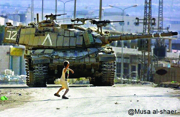 © MUSA AL-SHAER. Menino palestino enfrenta tanque de Israel em 2002 na Cisjordânia