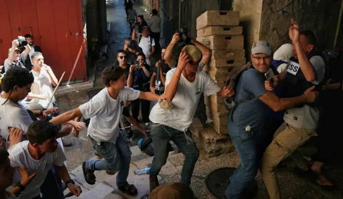 Na Cidade Velha de Jerusalém, o jornalista israelense Nir Hasson (Haaretz) tenta proteger o colega palestino Saif al Qawasmi do ataque de jovens sionistas (foto: Maya Levin/Haaretz)