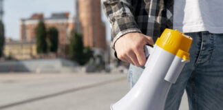 Sindicato lança nesta segunda-feira canal de denúncia de assédio no ambiente de trabalho homem com um megafone