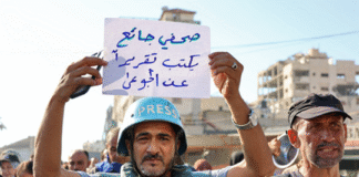 “Israel, pare de matar de fome jornalistas de Gaza para silenciar a verdade!”, exige a FIJ Manifestante segura uma placa com os dizeres em árabe “um jornalista faminto escreve uma reportagem sobre os famintos” durante um protesto de jornalistas contra a fome no distrito de Rimal, na Cidade de Gaza, em 19 de julho. Crédito: Omar Al-Qattaa / AFP