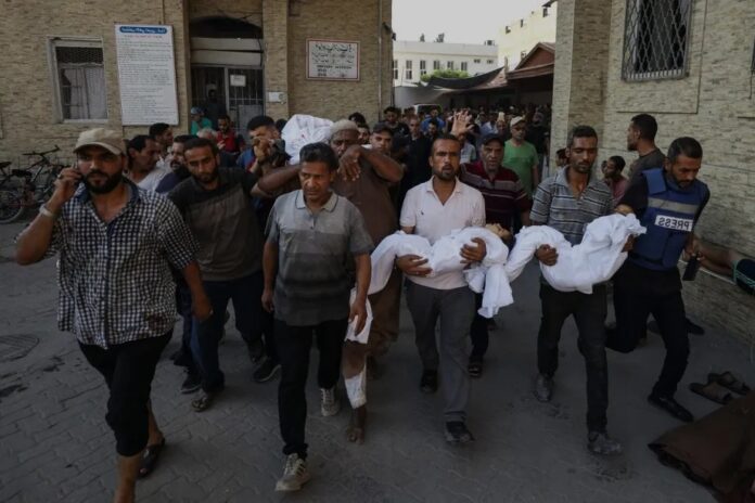 Palestinos carregam pessoas assassinadas em ataque israelense à casa da família Abu Sharia, no sul da Cidade de Gaza, em 21 de agosto de 2025 (Khames Alrefi – Agência Anadolu)