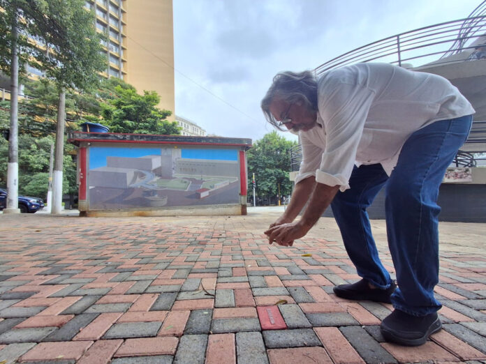 Sergio Gomes fotografa o nome de Mouzar Benedito, o primeiro tijolo instalado no Calçadão. Foto: Kleber Pagu.