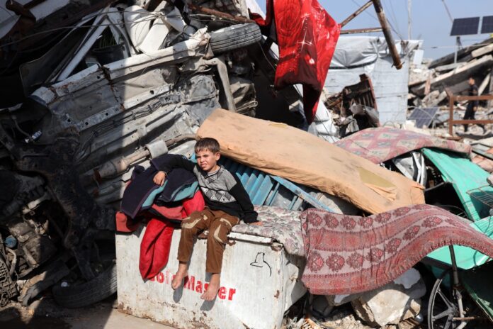 Criança palestina senta-se perto da tenda de sua família no campo de refugiados de Jabalia, em Gaza, em 6 de janeiro de 2026 (foto de Majdi Fathi/NurPhoto)