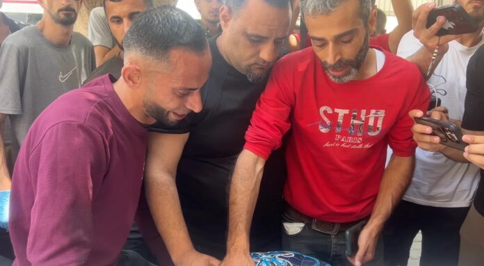 Youssef Suleiman (de camisa vermelha) chora sobre o corpo de Jad, seu filho de 8 anos, morto em ataque aéreo israelense em 8 de junho de 2026 (captura de tela de vídeo)