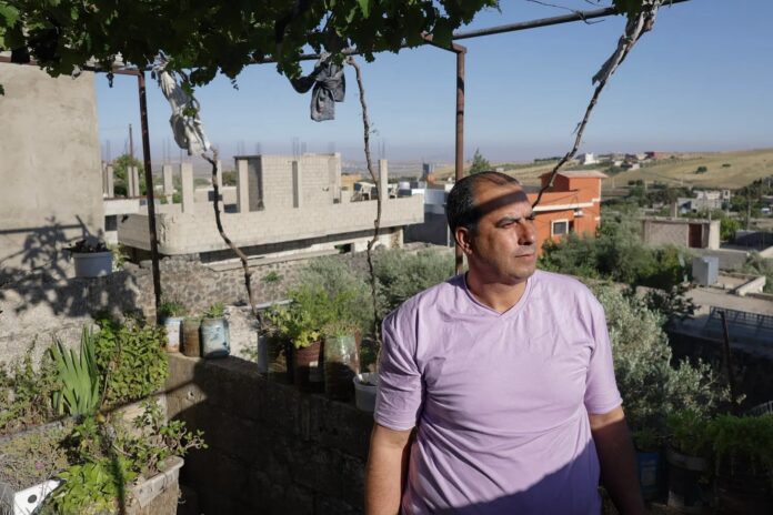 Mohammed Al-Ali olha da sua varanda na direção da sua casa demolida em Quneitra, em 9/6/2026 (foto: Cian Ward)