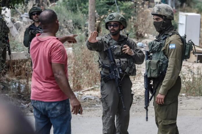 No campo de refugiados de Tulkarm, soldados israelenses discutem com palestino deslocado, em 21 de junho de 2026 (foto: Aseel Mafarjeh)