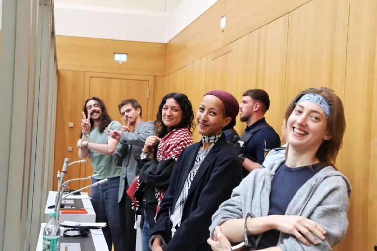 Daniel Tatlow-Devally, Leandra Rollo, Vi Kovarbasic, Crow Tricks e Zo Hailu, os "5 de Ulm", aparecem algemados e atrás de vidro à prova de balas durante julgamento em Stuttgart, Alemanha (foto: Hebh Jamal)