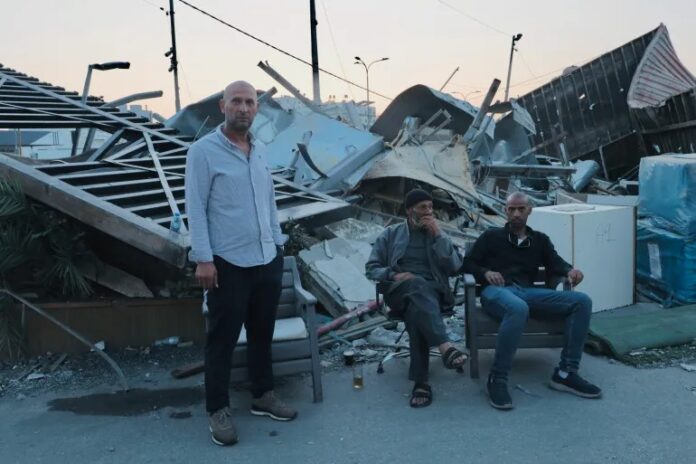 Sufian al-Qawasmi (à esquerda) em frente aos escombros de uma fábrica de sua família em Hebron, após a demolição realizada por Israel (foto: Sari Jaradat/Al Jazeera)